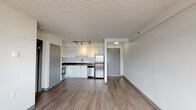 Located on the tenth floor at 29 St. Helens Avenue in Tacoma, Washington, Unit 1002 is a well-appointed residence featuring a thoughtful open-concept layout with clean, modern finishes throughout. The main living area is spacious and bright, with wood-style laminate flooring, neutral-toned walls, and a textured ceiling. Large windows allow natural light to fill the room while offering scenic views of the Tacoma waterway and cityscape beyond, enhanced by a baseboard heating system along the perimeter.

The kitchen is efficiently designed and fully equipped with white cabinetry, dark laminate countertops, a stainless steel refrigerator, dishwasher, and a stainless electric range with a vent hood above. Track lighting illuminates the workspace, and the layout flows seamlessly into the open living area, making the space feel connected and functional.

The bedroom is a well-proportioned room featuring plush carpeting, neutral walls, a textured ceiling, and a window framing views of the water and city. The bathroom is outfitted with a full tub and shower combination, accessibility grab bars, and easy-to-maintain vinyl flooring, reflecting a practical and accessible design. Ample closet space is also present throughout the unit, rounding out this comfortable Tacoma residence.