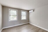 Located at 3800 Shepherd St in Brentwood, MD, this thoughtfully updated one-bedroom, one-bathroom residence offers a clean, modern aesthetic across its single-floor layout. Light-toned luxury vinyl plank flooring flows consistently throughout, creating a cohesive and easy-to-maintain living environment. Neutral gray walls and bright white trim lend the interior a fresh, contemporary feel.

The kitchen is a standout feature, equipped with white shaker-style cabinetry, granite countertops with subtle veining, stainless steel appliances including a gas range, and a stainless undermount sink beneath a window that brings in natural light. The layout is efficient and well-appointed for everyday cooking.

The bedroom is generously sized and benefits from multiple windows fitted with blinds, providing views of the surrounding greenery and allowing excellent natural light. A wall-mounted ductless mini-split unit ensures year-round climate comfort. Three closets throughout the unit offer notable storage capacity for a home of this size.

The living and dining areas share an open, airy feel, with additional windows continuing the bright, welcoming ambiance. The bathroom features a tub-shower combination with marble-style tile surround, white subway tile wainscoting, and a window for natural ventilation. Overall, this residence delivers a clean, move-in-ready living experience with modern upgrades throughout.