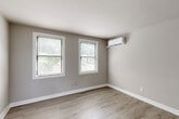Located at 3800 Shepherd St in Brentwood, MD, this thoughtfully updated one-bedroom, one-bathroom residence offers a clean, modern aesthetic across its single-floor layout. Light-toned luxury vinyl plank flooring flows consistently throughout, creating a cohesive and easy-to-maintain living environment. Neutral gray walls and bright white trim lend the interior a fresh, contemporary feel.

The kitchen is a standout feature, equipped with white shaker-style cabinetry, granite countertops with subtle veining, stainless steel appliances including a gas range, and a stainless undermount sink beneath a window that brings in natural light. The layout is efficient and well-appointed for everyday cooking.

The bedroom is generously sized and benefits from multiple windows fitted with blinds, providing views of the surrounding greenery and allowing excellent natural light. A wall-mounted ductless mini-split unit ensures year-round climate comfort. Three closets throughout the unit offer notable storage capacity for a home of this size.

The living and dining areas share an open, airy feel, with additional windows continuing the bright, welcoming ambiance. The bathroom features a tub-shower combination with marble-style tile surround, white subway tile wainscoting, and a window for natural ventilation. Overall, this residence delivers a clean, move-in-ready living experience with modern upgrades throughout.
