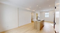 This 700 square foot two-story home in Calgary, AB offers a blend of modern design and efficient living. The space is divided into 8 rooms across two floors, with 360 sq ft on the ground floor and 340 sq ft on the upper level.

The bathroom features a clean, minimalist design with large light-colored tiles, a white bathtub-shower combination, and modern black fixtures. The vanity incorporates wood elements, adding warmth to the space.

The kitchen is a highlight, boasting contemporary white cabinetry paired with light wood lower cabinets. Stainless steel appliances, including a French door refrigerator and over-the-range microwave, complement the sleek design. A marble-look backsplash and countertops add a touch of luxury, while a central island with a sink provides additional workspace.

Throughout the home, light wood flooring creates a cohesive look and enhances the sense of space. The rooms feature crisp white walls, recessed lighting, and strategically placed windows that allow natural light to flood the interiors. Built-in storage solutions maximize the available space.

Despite its compact size, the layout feels open and airy, with a seamless flow between living areas. This property exemplifies modern urban living, offering style and functionality in a well-designed package.