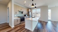 Located in Atlanta's vibrant East Side, this modern single-floor residence showcases a thoughtfully designed open-concept layout with contemporary finishes throughout. The kitchen serves as the heart of the home, featuring light wood cabinetry with matte black hardware, quartz countertops, a subway tile backsplash, stainless steel appliances including a gas range and French door refrigerator, and a generous island with an undermount sink and pendant lighting. Rich hardwood-style flooring flows seamlessly from the kitchen into the spacious living area, which is bathed in natural light from large windows offering open views of the surrounding neighborhood. Ceiling fans are present throughout for added comfort. The bedrooms are carpeted for warmth and comfort, each with ceiling fans and windows that invite natural light. The bathrooms are finished to a high standard, featuring light wood vanities with quartz countertops, matte black fixtures, large framed mirrors, wood-look tile flooring, and tiled walk-in showers. The primary bathroom includes a soaking tub and a double vanity accessible via a stylish panel door. The overall aesthetic is clean, modern, and cohesive, making this a well-appointed residence in Atlanta, GA.
