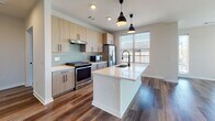 Located in Atlanta's vibrant East Side, this modern single-floor residence showcases a thoughtfully designed open-concept layout with contemporary finishes throughout. The kitchen serves as the heart of the home, featuring light wood cabinetry with matte black hardware, quartz countertops, a subway tile backsplash, stainless steel appliances including a gas range and French door refrigerator, and a generous island with an undermount sink and pendant lighting. Rich hardwood-style flooring flows seamlessly from the kitchen into the spacious living area, which is bathed in natural light from large windows offering open views of the surrounding neighborhood. Ceiling fans are present throughout for added comfort. The bedrooms are carpeted for warmth and comfort, each with ceiling fans and windows that invite natural light. The bathrooms are finished to a high standard, featuring light wood vanities with quartz countertops, matte black fixtures, large framed mirrors, wood-look tile flooring, and tiled walk-in showers. The primary bathroom includes a soaking tub and a double vanity accessible via a stylish panel door. The overall aesthetic is clean, modern, and cohesive, making this a well-appointed residence in Atlanta, GA.
