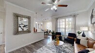 Located in the Briar Forest area of Houston, TX, this well-appointed one-bedroom, two-bathroom residence offers a thoughtfully designed single-floor layout. The open living and dining area forms the heart of the home, featuring rich hardwood-style flooring, crown molding, and a ceiling fan that add a polished, classic character. Large windows with plantation-style blinds bathe the space in natural light while offering views of the surrounding greenery. The galley-style kitchen is well-equipped with dark espresso cabinetry, granite-style countertops, stainless steel appliances, and a deep undermount sink — a functional and stylish space for cooking. A dedicated dining area sits just off the kitchen and living room, comfortably accommodating a full dining set. A built-in office nook with a granite desktop and floating shelves provides a compact yet efficient workspace. The spacious bedroom features plush carpeting, a ceiling fan, and direct access to a generous walk-in closet with built-in shelving. The primary bathroom offers a long dual-sink vanity with dark cabinetry, granite countertops, large-format tile flooring, and a full soaking tub. A second bathroom and a private patio complete this comfortable and versatile residence.