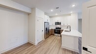 This single-story, 3-bedroom, 2-bathroom home in Woodstock, Georgia offers a clean, modern aesthetic throughout. The kitchen is a standout feature, showcasing white shaker upper cabinets paired with warm wood-toned lower cabinets, white quartz countertops, and stainless steel appliances including a side-by-side refrigerator, range, and over-the-range microwave. Light luxury vinyl plank flooring runs through the kitchen, adding warmth and easy maintenance. A dedicated pantry with built-in shelving provides generous storage.

The three bedrooms are carpeted and filled with natural light from multiple windows dressed with white blinds. Ceiling fans are present in each bedroom. The spacious primary bedroom features two windows with outdoor views and is complemented by a walk-in closet with built-in shelving. One bedroom offers direct outdoor access through a glass-panel door.

Both bathrooms reflect a contemporary design with light wood-toned vanities, white countertops, matte black hardware and fixtures, and light vinyl plank flooring. One bathroom includes a tiled tub-shower combination. The home also features a hallway and two closets, ensuring practical storage throughout. The overall ambiance is bright, clean, and move-in ready.