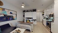 Located on East 6th Street in one of Austin's most dynamic neighborhoods, this efficiently designed studio unit offers a thoughtful single-floor layout that maximizes every square foot. The main living area centers around a built-in wall unit with integrated open shelving that frames the sleeping area, providing generous storage while defining the space. Light hardwood-style flooring runs throughout, complementing the clean white walls and creating a bright, cohesive aesthetic. A ceiling fan with light fixture keeps the space comfortable, and bold contemporary artwork adds a vibrant focal point to the living area.

The galley-style kitchen is a standout feature, outfitted with full-height white cabinetry, a gray subway tile backsplash, white quartz countertops, and a complete suite of stainless steel appliances including a refrigerator, range, microwave, and dishwasher. Ample upper and lower cabinetry ensures plentiful storage for all kitchen essentials.

The bathroom continues the modern, clean design language with white cabinetry, a single vanity with undermount sink, a large mirror, and a tub-shower combination accented by gray tile surround. Light tile flooring ties the room together for a polished, cohesive finish throughout this well-appointed urban studio.