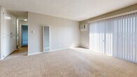 Located at 700 W La Jolla St in Placentia, California, this two-bedroom, two-bathroom single-story residence offers a practical and well-organized layout. The living room is bright and carpeted, featuring a wall-unit air conditioner, a vertical heater, and a sliding glass door with vertical blinds that opens to a private balcony, filling the space with natural light. Adjacent to the living room, the dining area connects seamlessly to the kitchen, which is outfitted with white cabinetry, granite-style countertops, a gas range, stainless steel appliances including a dishwasher, and light wood-style flooring throughout. A pantry provides additional storage convenience. Both bedrooms feature soft carpeting and neutral warm-toned walls. The primary bedroom includes a sliding-door closet and connects to a hallway, while the second bedroom benefits from a large window with outdoor views of surrounding greenery. Five closets throughout the unit ensure generous storage capacity. The two bathrooms are finished with granite-style vanity countertops and light wood-style flooring; one features a full bathtub and shower combo. The textured ceilings and neutral color palette throughout create a clean, cohesive aesthetic well-suited for comfortable everyday living.