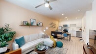 Located at 6755 W McDowell Rd in Phoenix, AZ, this thoughtfully designed single-floor unit makes excellent use of its cozy footprint. The open-concept living and kitchen area serves as the heart of the space, where light-toned luxury vinyl plank flooring, recessed lighting, and a ceiling fan create a bright, comfortable atmosphere. Large windows allow natural light to fill the living area, which offers ample room for a sectional sofa and seating. Warm peach-toned accent walls add a welcoming pop of color.

The kitchen is efficiently laid out with clean white cabinetry extending to the ceiling, marble-style countertops, a stainless steel sink, and a full suite of stainless steel appliances including a refrigerator, electric range, built-in microwave, and dishwasher. A dining area sits adjacent to the kitchen, providing a practical space for meals.

The bedroom features plush carpet, a ceiling fan, a wall-mounted mini-split HVAC unit, and a window with outdoor views. It connects to a generously sized walk-in closet with built-in shelving and hanging rods. The bathroom is clean and well-appointed, featuring a soaking tub with shower, a marble-top vanity, and tile flooring. A hallway connects the private and shared areas of the unit seamlessly.