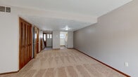 Located at 1580 Prospect Street in Elyria, Ohio, this two-story home offers a practical and well-organized layout across three bedrooms and three bathrooms. The main floor features a carpeted living room with a distinctive exposed brick accent wall, providing a warm, textural element to the space. The kitchen is equipped with oak cabinetry, light countertops, tile flooring, and includes appliances such as a refrigerator and dishwasher, with a window that allows natural light to filter in. A hallway connects the main living areas, featuring tile flooring and a staircase with a classic wood banister and black metal railing that leads to the upper level. The bedrooms are carpeted and feature ceiling fans with light fixtures, neutral-toned walls, and wood-trimmed doors, offering a comfortable and consistent aesthetic. The generously sized primary bedroom benefits from natural light through vertical blinds. Storage is thoughtfully incorporated, including a louvered-door closet with built-in shelving. The bathrooms feature tile flooring, oak vanities, and one includes a striking cinder block accent wall, adding an industrial touch. The home's overall ambiance is understated and functional, with consistent neutral tones and warm wood accents throughout.