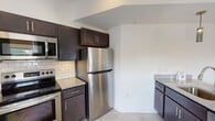 Located at 1805 Monument Ave in Richmond, Virginia, this single-floor residence sits along one of the city's most recognized historic corridors. The open layout, as revealed in the floor plan, flows from a well-appointed kitchen through a generous living area and into the sleeping quarters, offering a practical and comfortable arrangement throughout.

The kitchen is outfitted with dark espresso cabinetry, granite-style countertops, and a full suite of stainless steel appliances, including an electric range, built-in microwave, and refrigerator. A classic subway tile backsplash adds a clean, timeless detail to the cooking space, which receives natural light through nearby windows.

The bedrooms feature neutral carpet flooring and crisp white walls, with each room offering access to a walk-in closet with wire shelving. Windows allow ample natural light to fill the spaces, lending an airy, bright character to the rooms.

The bathrooms are finished with granite-topped vanities and white subway tile surrounding the soaking tub and shower. One bathroom features large windows overlooking Monument Avenue, providing a notable and distinctive urban view directly from within the unit.

Light-toned flooring runs through the common areas, complementing the overall clean and modern aesthetic of this well-maintained residence.
