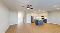 Located at 412 Ophelia Way in Greenville, NC, this well-designed two-story home offers two bedrooms, three bathrooms, and a thoughtfully organized layout spread across two floors. The main level serves as the heart of the home, featuring a seamless open-concept living, dining, and kitchen area finished with light wood-tone flooring and recessed lighting throughout. The kitchen stands out with its two-tone cabinetry — crisp white upper cabinets paired with bold navy lower cabinets — a light quartz countertop island, stainless steel appliances, and a classic subway tile backsplash. A ceiling fan anchors the living area, while a large window and glass-panel door fill the dining space with natural light. The attached garage is clean and well-lit, equipped with an automatic opener. A staircase with warm wood treads and white risers connects the floors, accented by a wood handrail. Upstairs, the generously sized primary bedroom features a ceiling fan, hardwood-style flooring, and access to multiple walk-in closets with built-in wire shelving. The primary bathroom includes a soaking tub with tiled surround. Additional highlights include a dedicated laundry room, a pantry, and ample closet storage across five closets throughout the home.