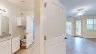 Located at 321 Mohegan Ave in Bluffton, SC, this well-appointed 2-bedroom, 2-bathroom single-story home offers a thoughtfully designed layout with a clean, modern aesthetic. The open-concept living area features light wood-look flooring and large windows that invite abundant natural light and offer views of the surrounding greenery, creating a bright and welcoming atmosphere throughout.

The kitchen is a functional highlight, equipped with stainless steel appliances including a refrigerator, range, and microwave. White shaker-style cabinetry extends to the ceiling for generous storage, while granite countertops and a peninsula with a sink add both style and practicality.

The living and dining areas flow seamlessly, with a glass door providing direct outdoor access. Both bedrooms are carpeted for comfort, with the generously sized primary bedroom offering ample space and ceiling fan. The primary bathroom features granite countertops, white cabinetry, a large vanity mirror, and a tub-shower combination. A dedicated walk-in closet with wire shelving provides excellent storage. The second bathroom is similarly well-finished. Wood-look flooring extends through the hallways and common areas, tying the home's design together cohesively.
