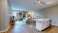 Located at 220 Vine St in Columbus, Ohio, this well-appointed 3-bedroom, 3-bathroom residence offers a thoughtfully designed single-floor layout with generous living space. The open-concept kitchen and living area serves as the heart of the home, featuring light hardwood-style flooring, track lighting, and large windows that invite abundant natural light. The kitchen is outfitted with white shaker cabinetry, stainless steel appliances, a subway tile backsplash, and a sizeable island with a built-in sink and bar seating — ideal for both cooking and casual dining. The living area flows seamlessly from the kitchen, creating an airy, connected atmosphere. The spacious primary bedroom offers plush carpeting and an outdoor view of the surrounding greenery, complemented by ample closet storage. Two additional bedrooms provide comfortable accommodations, each with carpeted flooring and natural light. The three bathrooms are finished with clean white vanities, framed mirrors, and wood-look flooring. A dedicated laundry room houses a stacked washer and dryer for added convenience. Five closets throughout the unit ensure excellent storage capacity. A private patio rounds out this well-equipped residence, offering an outdoor retreat in the heart of Columbus.