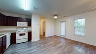 This single-floor residential unit offers a clean, functional layout designed for comfortable everyday living. Durable wood-look flooring flows consistently throughout the entire space, creating a cohesive and easy-to-maintain aesthetic.

The open-concept living and dining area is bright and welcoming, featuring a ceiling fan with light fixture and multiple windows fitted with blinds that allow natural light to filter in. A private entry door with sidelights connects the living space to the exterior. The kitchen is positioned adjacent to the living area and is equipped with rich dark wood cabinetry, light countertops, a double-basin sink, and white appliances including a refrigerator, electric range, built-in microwave, and dishwasher. A programmable thermostat is conveniently located nearby.

The bedroom is generously sized, featuring its own ceiling fan, two windows, and a walk-in closet outfitted with wire shelving for organized storage. An additional closet provides further storage options. The bathroom is clean and functional, featuring a full tub and shower combination with tiled surround and chrome fixtures. The unit's straightforward, well-maintained design makes it a practical and comfortable living space.