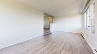 Located on Woodridge Crescent in Ottawa, this thoughtfully updated 2-bedroom, 1-bathroom unit offers a clean, modern aesthetic throughout its well-organized single-floor layout. Light-toned laminate flooring flows consistently across the living spaces, complemented by crisp white walls and bright, neutral tones that create a welcoming atmosphere.

The spacious living room features a subtle split-level design with a few steps leading to the hallway, adding architectural character to the open space. Large windows allow generous natural light to fill the room, with views of the surrounding neighbourhood and nearby greenery.

The kitchen is efficiently designed with sleek white cabinetry, grey countertops, a white subway tile backsplash, and stainless steel appliances including a refrigerator and electric range. Light tile flooring and a window with an urban view complete the functional space.

Both bedrooms are well-proportioned, each featuring laminate flooring, white walls, and built-in sliding closets that maximize storage. The primary bedroom benefits from a window overlooking the cityscape, offering an elevated perspective. The second bedroom also enjoys natural light through its own window.

The bathroom is finished in a clean, contemporary style with large-format white wall tiles surrounding a full soaker tub, neutral floor tiles, and white cabinetry. Two hallways and a dedicated closet provide additional storage and ease of circulation throughout the unit.