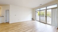 This well-appointed 2-bedroom, 1-bathroom unit in Milwaukee's 53212 zip code offers a thoughtfully designed layout across a single floor. Light hardwood-style flooring flows throughout the main living areas, creating a clean, cohesive aesthetic.

The open living room is bathed in natural light, anchored by large sliding glass doors that lead to a private balcony with views of the surrounding neighborhood. A chandelier overhead adds a touch of warmth to the space. The galley-style kitchen features white cabinetry, dark countertops, a full suite of stainless steel appliances including a refrigerator, range, microwave, and dishwasher, and a peninsula with a built-in sink — ideal for casual dining or food prep.

Both bedrooms are carpeted for comfort and include windows that bring in natural light and outdoor views. Each bedroom benefits from dedicated closet space, with two closets total throughout the unit. The primary bedroom is a comfortable size with access to an additional walk-in closet area.

The bathroom is finished with clean white fixtures, a combination tub and shower with a handheld showerhead, a white vanity with an integrated sink, and the same light hardwood-style flooring found throughout the rest of the home. The overall ambiance is bright, modern, and move-in ready.