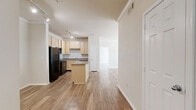 Located on Old Hickory Blvd in Nashville, TN, this single-floor, 2-bedroom, 2-bathroom residence offers a well-designed layout with consistent hardwood-style flooring throughout. The open-concept kitchen is a standout feature, equipped with light wood cabinetry, granite-style countertops, a curved center island, track lighting, and a full suite of black appliances including a refrigerator, range, microwave, and dishwasher. The kitchen flows seamlessly into the living area, which is bathed in natural light from a large bank of windows and a glass-panel entry door, and is finished with elegant crown molding. Both bedrooms are comfortably sized, with the primary bedroom offering high ceilings, its own en-suite bathroom, and access to multiple walk-in closets outfitted with wire shelving systems. The second bedroom also benefits from crown molding, a ceiling fan, and a bright window with outdoor views. The bathrooms feature wood-toned vanities with stone-style countertops and large mirrors. Additional highlights include five closets total, an in-unit laundry area, and ample storage throughout — making this a highly functional and inviting Nashville home.