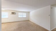 Located at 2601 Blair Mill Road in Willow Grove, PA, this two-bedroom, one-bathroom apartment offers a functional and comfortable single-floor layout. The combined kitchen and living room serves as the heart of the home, with the living area featuring neutral wall-to-wall carpeting, baseboard heating, and a sliding glass door that opens onto a private covered balcony overlooking the community grounds and green spaces. The galley-style kitchen is well-appointed with white cabinetry, granite-look countertops, a tile backsplash, a gas range, built-in microwave, refrigerator, and a double-basin sink — all set on durable tile flooring. Both bedrooms are carpeted and bright, with the primary bedroom offering generous proportions, multiple windows for natural light, a wall-mounted AC unit, and baseboard heating. The second bedroom also features carpeting and convenient closet access. The full bathroom includes a soaking tub with white tile surround. Additional storage is provided by a dedicated closet. The covered balcony extends the living space outdoors, providing a relaxed spot with open views of the surrounding landscaped community.