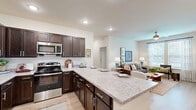 Located at 200 Walton Way Rd in Villa Rica, Georgia, this single-floor, 2-bedroom, 2-bathroom residence offers a thoughtfully designed layout with modern finishes throughout. Light wood-style flooring flows through the main living areas, complementing the neutral color palette and creating a warm, cohesive ambiance.

The kitchen is a standout feature, showcasing rich dark wood cabinetry, light granite countertops with a subway tile backsplash, and a full suite of stainless steel appliances. A peninsula with bar seating provides a convenient casual dining option and opens directly to the living area, enhancing the space's open feel.

The living room is bright and inviting, with large windows dressed in elegant curtains that allow ample natural light to fill the room. A ceiling fan adds comfort and functionality.

The primary bedroom is a comfortable retreat with natural light from a window and easy access to an en-suite bathroom. The primary bath features a granite-topped vanity with dark wood cabinetry, wood-style flooring, a glass-enclosed shower, and a walk-in closet with built-in shelving. The second bedroom also enjoys natural light and a ceiling fan. A second full bathroom with a tub-shower combination completes the layout. A hallway and closet round out this efficiently designed home.