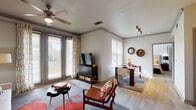 This single-story residence offers a thoughtfully designed layout that balances comfort and functionality across its living spaces. The open-concept living and dining area serves as the heart of the home, featuring wood-look flooring, crown molding, and a ceiling fan overhead. Large windows and a set of glass doors flood the space with natural light, while a dedicated dining area accommodates a full table and seating. Track lighting along the adjacent wall adds a modern touch.

The kitchen is well-appointed with warm wood cabinetry extending to the ceiling, granite-style countertops, stainless steel appliances including a refrigerator, range, and built-in microwave, and under-cabinet lighting. Light hardwood flooring continues throughout, lending a cohesive feel to the space.

The bedroom is a calm retreat, offering natural light through a window with outdoor views, a ceiling fan, and direct access to a spacious walk-in closet outfitted with wire shelving and multiple hanging rods on three walls—providing generous storage.

The bathroom features a single-sink vanity with wood cabinetry, a wide mirror, and a tub-shower combination, all complemented by wood-look flooring that ties the space together.