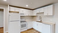 Located at 131 W 200 N in Salt Lake City's Capitol Hill neighborhood, this well-appointed 2-bedroom, 1-bathroom residence offers a clean, modern aesthetic throughout its thoughtfully designed single-floor layout. Light-toned hardwood-style flooring runs seamlessly through every room, complemented by neutral gray-white walls and recessed lighting that create a bright, cohesive atmosphere.

The open-concept living, dining, and kitchen area serves as the heart of the home. The kitchen features white shaker-style cabinetry with brushed nickel hardware, light quartz countertops, a stainless steel sink with a gooseneck faucet, and white appliances including a refrigerator, range, microwave, and dishwasher. A sliding glass door in the living area connects to a private balcony, flooding the space with natural light and offering outdoor views of the surrounding neighborhood.

Both bedrooms are comfortably sized, with the primary bedroom offering a window with city views and a wall unit for climate control. Each bedroom is served by its own closet. The full bathroom is finished with white shaker vanity cabinetry, quartz countertops, a framed mirror, and warm vanity lighting. A utility room and additional storage round out the functional layout of this move-in-ready Salt Lake City residence.