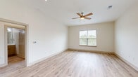 Located in Ocean Isle Beach, NC, this well-designed single-story home offers 2 bedrooms and 2 bathrooms across a thoughtfully laid-out floor plan. The open-concept living, dining, and kitchen area serves as the heart of the home, featuring light hardwood-style flooring that flows seamlessly throughout. The modern kitchen is equipped with stainless steel appliances, a central island with a white quartz countertop and undermount sink, shaker-style cabinetry with gold hardware, a subway tile backsplash, and stylish pendant lighting — a functional and visually appealing space for cooking and entertaining. The spacious primary bedroom includes a ceiling fan, natural light from a window with outdoor views, and access to a well-appointed en-suite bathroom featuring a wide vanity with white quartz countertops, gold hardware accents, and a large mirror. The second bedroom is bright and versatile, also benefiting from natural light. Three closets, including a walk-in with wire shelving, provide ample storage. A dedicated laundry area houses a full-size washer and dryer with overhead shelving. The attached garage offers additional storage and parking. Throughout, the home maintains a clean, neutral palette with crisp white walls and light flooring, creating a bright and welcoming ambiance.