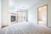 Located at 135 Marcou Rd in Onalaska, WI, this well-appointed 2-bedroom, 2-bathroom residence offers a comfortable and functional single-floor layout. The open-concept living area is a standout, featuring plush carpeting, recessed lighting, and a corner gas fireplace framed with warm wood trim. A sliding glass door provides direct access to a private balcony with outdoor views, filling the space with natural light. The kitchen is designed for efficiency, boasting warm oak cabinetry, a breakfast bar peninsula, hardwood-style flooring, and white appliances, including a refrigerator, stove, and dishwasher. The entry area flows seamlessly from the kitchen, complemented by a ceiling fan above. Both bedrooms are carpeted and include ceiling fans and windows that bring in natural light. The primary bedroom features a spacious walk-in closet with wire shelving for ample storage. The two bathrooms are finished with tile flooring and oak vanities; one includes a soaking tub with grab bar and the other connects conveniently to the walk-in closet. A dedicated laundry area with a stacked washer and dryer and overhead cabinetry adds everyday convenience to this thoughtfully designed home.