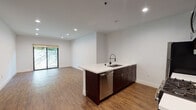 Located at 6900 Bonita Terr in Los Angeles, CA 90028, this modern single-floor unit offers a clean, contemporary design throughout. The open-concept living and kitchen area is anchored by warm wood-style flooring and crisp white walls, creating a bright and airy atmosphere. Recessed lighting throughout enhances the spacious feel of the main living area, which flows seamlessly toward sliding glass doors that invite natural light and provide access to a lush outdoor space.

The kitchen is well-appointed with rich dark wood cabinetry, white quartz countertops, and a full suite of stainless steel appliances, including a gas range, microwave, refrigerator, and dishwasher. A peninsula with an undermount sink offers additional prep space and a casual seating area, while a subtle tile backsplash adds a refined finishing touch.

The bedroom features the same wood-style flooring, a stylish wall sconce, and ample room for furnishings. The bathrooms are finished with a clean, minimalist aesthetic, showcasing white subway tile surrounds, soaking tubs, white quartz vanity tops, and dark wood cabinetry that ties the design together cohesively. The overall ambiance is modern, functional, and move-in ready.