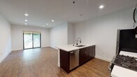 Located at 6900 Bonita Terr in Los Angeles, CA 90028, this modern single-floor unit offers a clean, contemporary design throughout. The open-concept living and kitchen area is anchored by warm wood-style flooring and crisp white walls, creating a bright and airy atmosphere. Recessed lighting throughout enhances the spacious feel of the main living area, which flows seamlessly toward sliding glass doors that invite natural light and provide access to a lush outdoor space.

The kitchen is well-appointed with rich dark wood cabinetry, white quartz countertops, and a full suite of stainless steel appliances, including a gas range, microwave, refrigerator, and dishwasher. A peninsula with an undermount sink offers additional prep space and a casual seating area, while a subtle tile backsplash adds a refined finishing touch.

The bedroom features the same wood-style flooring, a stylish wall sconce, and ample room for furnishings. The bathrooms are finished with a clean, minimalist aesthetic, showcasing white subway tile surrounds, soaking tubs, white quartz vanity tops, and dark wood cabinetry that ties the design together cohesively. The overall ambiance is modern, functional, and move-in ready.