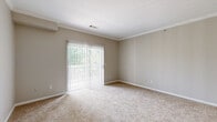 Located at 3868 Central Pike in Nashville, Tennessee, this two-bedroom, one-bathroom single-floor residence offers a well-organized layout with a neutral, move-in-ready aesthetic throughout. The living room is generously sized, featuring plush carpet, crown molding, and large sliding glass doors fitted with vertical blinds that invite abundant natural light and provide views of the surrounding greenery. The kitchen is efficiently designed with light-toned cabinetry, white countertops, black appliances including a range and refrigerator, a dark-countered peninsula, and wood-look flooring that adds warmth to the space. A dedicated dining area connects naturally to the kitchen for convenient everyday living. The primary bedroom is a comfortable retreat, complete with carpet flooring, a ceiling fan, large windows overlooking outdoor greenery, and access to a walk-in closet. The second bedroom also features carpet, ample natural light through a wide window, and its own closet. The full bathroom is finished with wood-look tile flooring, a tub-shower combination, a vanity with storage, and recessed lighting. Additional practical spaces include a hallway, laundry area, and utility room, rounding out the functional floor plan of this Nashville residence.