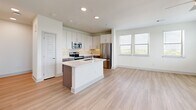 Located in Houston's Northside neighborhood, this well-appointed 2-bedroom, 2-bathroom single-story home offers a clean, modern aesthetic with thoughtful design throughout. The open-concept living and kitchen area serves as the heart of the home, featuring light wood-look flooring, recessed lighting, and a ceiling fan. A bank of windows floods the living space with natural light while offering pleasant outdoor views. The kitchen is a standout, boasting a two-toned cabinet design with white upper cabinets and gray lower cabinets, a decorative tile backsplash, quartz countertops, a large center island with an undermount sink, and a full suite of stainless steel appliances including a refrigerator, range, microwave, and dishwasher. A dedicated pantry provides additional storage. The two bedrooms are carpeted and bright, each with windows framing outdoor views and ceiling fans overhead. The primary bedroom is generously sized and includes a well-organized walk-in closet with built-in shelving and hanging rods. Both bathrooms feature gray vanity cabinetry with white countertops and wood-look tile flooring. A hallway connects the living areas to the bedrooms, and a dedicated laundry space adds everyday convenience. With four closets total, storage is plentiful throughout this efficiently designed home.