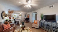 Located at 1601 Hogan Ln in Conway, Arkansas, this single-story residence offers a functional and comfortable layout across two bedrooms and two full bathrooms. The open-concept living and dining area flows seamlessly into the kitchen, creating a connected, sociable atmosphere. Ceiling fans are present throughout the home, contributing to both comfort and air circulation. The living room features plush carpeting, a textured ceiling, and ample space for relaxed seating arrangements. The kitchen is well-equipped with light wood cabinetry, a peninsula breakfast bar, full appliance suite including a refrigerator, range, microwave, and dishwasher, plus durable hardwood-style flooring. A dedicated dining area sits adjacent to the kitchen, ideal for everyday meals. The primary bedroom is generously proportioned, offering a large window with outdoor views, soft carpet, a ceiling fan, and dual closets providing excellent storage. A connected bathroom adds convenience. The second bedroom similarly features carpet, a ceiling fan, and closet access, with its own adjacent bathroom. Both bathrooms include a tub-shower combination with sliding glass doors, light wood vanities, and overhead cabinetry. A hallway connects the private and shared spaces efficiently, and an in-unit laundry closet adds everyday practicality.