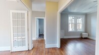 Located at 773 Farmington Ave in West Hartford, CT, this single-floor residence blends classic architectural charm with functional living spaces. Rich hardwood floors extend throughout the main living and bedroom areas, complemented by crisp white crown molding and generously sized baseboards that reflect the home's traditional character.

The living spaces are connected by elegant multi-pane French doors, allowing natural light to flow freely between rooms. Each room features cast iron radiators, adding a timeless aesthetic detail while providing efficient heating. The neutral gray and soft yellow color palette enhances the bright, airy atmosphere throughout.

The kitchen is well-equipped with warm honey-toned wood cabinetry, granite-style countertops, a subway tile backsplash, and a full suite of stainless steel appliances including a gas range, dishwasher, and refrigerator. A dedicated exterior door in the kitchen provides convenient backyard access, and a window invites natural light into the space.

The bedrooms are spacious and sun-filled, each with large double-hung windows offering outdoor views and hardwood flooring. The bathroom features light vinyl flooring, a tiled tub surround, and a cast iron radiator consistent with the home's period-inspired details. Overall, the space offers a comfortable blend of classic character and modern convenience.
