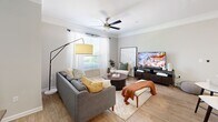 Located in Kennesaw, GA, this well-appointed 2-bedroom, 2-bathroom residence offers a thoughtfully designed single-floor layout with a bright, open feel throughout. The entryway hallway—flanked by louvered closet doors and ample storage—leads into the heart of the home, where the kitchen, dining, and living areas flow seamlessly together. The kitchen is equipped with stainless steel appliances, including a refrigerator, range, and microwave, complemented by dark espresso cabinetry, a subway tile backsplash, and a white-topped island ideal for casual dining or meal prep. The living room features crown molding, a ceiling fan, wood-style flooring, and large windows that invite generous natural light. The primary bedroom is generously sized with a wide window framing outdoor greenery, while the second bedroom also benefits from natural light and includes a dedicated closet. Both bathrooms are clean and functional, with one featuring a full soaking tub with white tile surround. A dedicated in-unit laundry room houses a full-size washer and dryer. With five closets distributed throughout, storage is plentiful. The neutral color palette and consistent flooring create a cohesive, move-in-ready ambiance across the entire residence.
