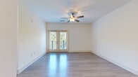 Located in Charlotte, NC, this well-designed single-floor residence on Vandelay Court offers a clean, modern aesthetic throughout. The open living area features light-toned hardwood-style flooring that reflects natural light beautifully, a ceiling fan, and a set of French doors that open to a private balcony overlooking lush greenery — creating a bright and airy atmosphere.

The kitchen is a standout feature, appointed with crisp white cabinetry extending to the ceiling for ample storage, granite countertops with subtle veining, a subway tile backsplash, and a full suite of stainless steel appliances including a range, microwave, dishwasher, and refrigerator. Pendant lighting and recessed fixtures illuminate the space, while a central island with a double sink adds both functionality and style.

The bedrooms are carpeted for comfort and each receives generous natural light through large windows with outdoor views. Ceiling fans are present in multiple rooms. The primary bathroom features an extended granite-topped vanity with white cabinetry, hardwood-style flooring, and access to a walk-in closet and a separate bathing area. Additional rooms with light hardwood-style flooring offer flexible use as a dining or flex space. The overall palette of soft whites and neutrals lends the entire residence a clean, contemporary feel.