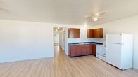 Located at 29456 Old Portland Rd in Adel, Iowa, this single-floor, 3-bedroom, 1-bathroom home offers a practical and functional layout across a comfortable footprint. The open-concept kitchen and living area serves as the heart of the home, featuring light wood-look flooring, a ceiling fan, and large windows that fill the space with natural light and offer views of the surrounding neighborhood. The kitchen is equipped with warm-toned wood cabinetry, dark countertops, a double sink, a white electric range, and a full-size refrigerator, providing ample storage and workspace. The living area offers generous space and includes a front entry door and baseboard heating. Three carpeted bedrooms are accessible via a central hallway, each featuring windows that bring in natural light and views of the surrounding rural landscape. Baseboard heaters are present throughout, and one bedroom includes a wall-mounted air conditioning unit. The full bathroom features wood-look flooring, a toilet, a bathtub with shower, and a grab bar. A dedicated utility room rounds out the layout, adding practical storage and mechanical access. The home's clean, neutral palette and efficient single-floor design make it a straightforward and livable space.