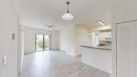 This well-designed 4-bedroom, 2-bathroom residence in Homestead, FL offers a thoughtful single-floor layout that maximizes comfort and functionality. Light-toned wood-look tile flooring flows consistently throughout the home, creating a bright and cohesive aesthetic.

The open-concept living and dining area is bathed in natural light, anchored by a ceiling fan and a stylish pendant light. Sliding glass doors lead to a private balcony with outdoor views, seamlessly connecting interior and exterior living spaces.

The kitchen is equipped with granite countertops, white cabinetry featuring modern bar-pull hardware, and white appliances including a range, microwave, dishwasher, and refrigerator. A raised breakfast bar adds a functional and social element to the space.

The primary bedroom offers a mirrored sliding-door closet and direct access to one of the two full bathrooms. Additional bedrooms are bright and well-proportioned, each with windows that invite natural light. Both bathrooms are finished with white cabinetry, taupe countertops, undermount sinks, and tub-shower combinations.

A dedicated in-unit laundry area houses a full-size washer and dryer with overhead shelving for added storage. The overall design is clean, neutral, and move-in ready.