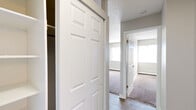 Located at 1920 E La Salle St in Colorado Springs, CO, this single-floor, one-bedroom, one-bathroom unit offers an efficient and practical layout. The kitchen is equipped with dark espresso-toned cabinetry offering generous storage, a stainless steel double sink, light countertops, and black appliances including a full-size refrigerator and range. Wood-look flooring runs throughout the kitchen and entry areas, adding warmth and durability to the space. The bedroom is a comfortable, carpeted room featuring a ceiling fan with light fixture, a baseboard heating unit, and a window with vertical blinds that allows natural light to filter in. A sliding closet door provides convenient storage access. The hallway connecting the rooms features additional closet space and transitions between the hard flooring and carpet. The bathroom includes a full soaking tub and shower combination with white tile surround and a safety grab bar. A textured ceiling is consistent throughout the unit, complementing the neutral gray wall tones. The overall layout is thoughtfully designed to maximize functionality within a cozy footprint, making it a practical option in the Colorado Springs area.