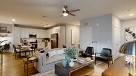 Located at 940 E Adams St in Jacksonville, FL, this thoughtfully designed two-bedroom, three-bathroom residence offers a cohesive blend of modern aesthetics and functional living. The open-concept kitchen and living area serves as the heart of the home, with the kitchen showcasing white flat-panel cabinetry, granite countertops, a classic subway tile backsplash, stainless steel appliances including a full-size refrigerator and built-in microwave, and light wood-look flooring that extends throughout the common areas. Track lighting overhead enhances the space's bright, contemporary character. The adjoining living room is generously proportioned, featuring a ceiling fan, large windows that invite natural light, and a neutral gray palette that creates a calm, inviting ambiance. Both bedrooms are carpeted and well-lit, each with ceiling fans, ample natural light from multiple windows, and access to dedicated closet space — including a walk-in closet with wire shelving. The three bathrooms are finished with wood-look tile flooring, glass-enclosed walk-in showers with large-format tile surrounds, white vanities, and refined fixtures. Each room reflects consistent attention to detail, making this a polished and comfortable residence in the heart of Jacksonville.