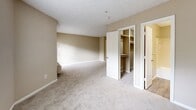 Located at 705 Powers Ferry Rd SE in Marietta, Georgia, this single-floor apartment offers a practical and well-organized layout across a compact footprint. The open-concept design connects the kitchen directly to the combined dining and living area, creating a seamless flow throughout the main living space. The kitchen is equipped with warm wood-toned cabinetry, a peninsula with a built-in sink and gray laminate countertops, a white electric coil range, a dishwasher, and a full-size refrigerator. Light wood-style flooring runs through the kitchen, transitioning to carpet in the living area. The living and dining space is bright, with windows that allow natural light to fill the room, and features a wall-mounted air conditioning unit. A full bathroom includes a tiled tub-shower combination with white square tile surround. The spacious carpeted area, visible from multiple angles, accommodates two closets — one of which features built-in shelving for added storage. A dedicated utility room and a private balcony round out the unit. Textured ceilings are consistent throughout, and neutral wall tones create a clean, understated aesthetic throughout the space.