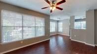 Located at 2752 Gaston Ave in Dallas, TX, this single-floor residence offers a well-designed layout with a cohesive, neutral color palette throughout. The open living area makes a strong first impression with rich, dark hardwood flooring, a ceiling fan with integrated lighting, and multiple windows fitted with horizontal blinds that allow generous natural light to fill the space. Track lighting accents the transition into the kitchen area.

The kitchen is a functional highlight, featuring dark espresso-toned cabinetry with sleek hardware, light granite-style countertops, and a full suite of stainless steel appliances including an electric range, built-in microwave, and dishwasher. A window above the kitchen brings in additional natural light.

The bedrooms are carpeted for comfort and each include ceiling fans. One bedroom features a walk-in closet with built-in shelving, while another includes a standard reach-in closet. Both offer windows with views of the surrounding greenery.

The bathrooms are finished with dark cabinetry, granite-style countertops, hardwood-style flooring, and full soaking tub and shower combinations with clean white surrounds. A dedicated walk-in closet is accessible from the primary bathroom. Additional storage is provided by a separate closet space with built-in shelving.
