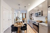 Located at 515 Royal Court in the heart of Charlotte, NC, this thoughtfully designed one-bedroom, one-bathroom residence offers a seamless blend of modern style and functional living. The open-concept layout connects the kitchen, dining, and living areas, creating an efficient and inviting flow throughout the space.

The kitchen is a standout feature, showcasing warm gray shaker-style cabinetry, granite countertops, a classic white subway tile backsplash, and a full suite of stainless steel appliances including a French door refrigerator, range, microwave, and dishwasher. A central island with a granite top provides additional prep and dining space, complemented by elegant pendant lighting overhead.

The living room is bright and welcoming, anchored by a large window and glass door that invite natural light. Soft sage-green accent walls carry through into the bedroom, which offers a comfortable, well-proportioned layout with large windows, wood-style flooring, and a dedicated closet for storage.

The bathroom features a granite-topped vanity with a wide mirror, wood-tone cabinetry, and a tub-shower combination. Wood-style flooring runs consistently throughout the residence, lending warmth and cohesion to every room. Recessed lighting throughout adds a polished, contemporary finish to this well-appointed Charlotte home.