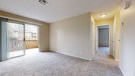 This single-floor unit offers three bedrooms, one bathroom, a living room, and a kitchen within a efficiently organized layout. Throughout the living areas and bedrooms, neutral beige walls are paired with plush, light-toned carpet, creating a consistent and understated aesthetic. Textured ceilings are found throughout the unit.

The living room provides a welcoming open feel, featuring a ceiling fan and direct access to a private outdoor balcony through a sliding glass door, allowing natural light to fill the space. The layout connects smoothly to the kitchen, which features warm oak cabinetry, light stone-finish countertops, white appliances including a refrigerator, electric range, and dishwasher, and wood-look vinyl flooring.

Each of the three bedrooms is carpeted and painted in matching neutral tones, with windows providing natural light. Two bedrooms include built-in closets with sliding or open-face doors and hanging rods for storage. The primary bedroom offers a notably spacious footprint.

The bathroom is equipped with a shower-tub combo, a wood-toned vanity with a stone-finish countertop, and wood-look vinyl flooring, maintaining the practical design carried throughout the unit.