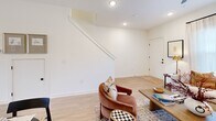 Located in Weaverville, NC, this two-story home offers a thoughtfully designed layout spread across two floors. The main level features an open-concept living, dining, and kitchen area bathed in natural light and finished with light-toned hardwood-style flooring throughout. The kitchen is equipped with sage green shaker cabinetry, stainless steel appliances including a side-by-side refrigerator, electric range, microwave, and dishwasher, complemented by clean white countertops and stylish black pendant lighting. The living room is bright and welcoming, with a ceiling fan, recessed lighting, and large windows that fill the space with natural light. A staircase connects the main floor to the upper level, where both bedrooms are located. The generously sized primary bedroom features plush carpet, a ceiling fan, and direct access to a walk-in closet with built-in wire shelving. The second bedroom is equally comfortable, with carpet flooring, a ceiling fan, and large windows. Three bathrooms serve the home, including a full bath on the upper level with a tub-shower combo, shaker-style vanity, and matte black fixtures. Clean white walls and modern finishes create a cohesive, contemporary feel throughout.