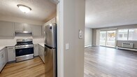 This well-appointed two-bedroom, one-bathroom unit in Malden, MA offers a comfortable and functional layout across a single floor. Consistent hardwood-style flooring flows throughout the space, tying each room together with a clean, cohesive look. Neutral warm-toned walls and textured ceilings add understated character to every room.

The open living area is generously sized, featuring dual windows that flood the space with natural light and views of the surrounding greenery. Baseboard heating runs along the perimeter, ensuring warmth throughout the colder months. A chandelier accent light adds a touch of elegance to the dining area.

The kitchen has been thoughtfully updated with grey shaker-style cabinetry, white quartz countertops, a subway tile backsplash, and a stainless steel gas range — offering both style and practicality.

Both bedrooms are well-proportioned, with the primary bedroom offering ample space, a window with outdoor views, and a louvered closet door. The second bedroom similarly benefits from natural light and baseboard heating.

The bathroom features a clean, tiled tub-shower combination with chrome fixtures, complemented by tile wainscoting for a polished finish. Overall, the unit presents a move-in ready, modernized living environment.