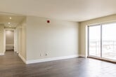Located at 508 Mohawk Rd E in Hamilton, Ontario, this well-appointed two-bedroom, one-bathroom unit offers a thoughtfully designed layout across a single floor. Dark hardwood-style flooring flows consistently throughout the space, complementing the neutral warm-toned walls and crisp white trim.

The open-concept kitchen is a standout feature, boasting rich dark espresso cabinetry, grey subway tile backsplash, granite countertops, a central island with additional seating potential, and a full suite of stainless steel appliances including a refrigerator, stove, and over-the-range microwave. A large window above the sink fills the kitchen with natural light and offers views of the surrounding neighbourhood.

The living room is bright and airy, anchored by a sliding glass door that provides outdoor views and additional natural light, along with a wall-mounted HVAC unit for year-round comfort.

Both bedrooms are well-sized, featuring the same consistent flooring and neutral tones. The primary bedroom includes a mirrored sliding-door closet, maximizing the sense of space.

The bathroom is finished to a high standard, featuring white subway tile walls, a soaker tub with a rainfall showerhead, dark tile flooring, and a granite-topped vanity — creating a clean and contemporary feel throughout.