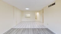Located at 8920 NW 8th Street in Miami, FL, this 2-bedroom, 2-bathroom unit offers a functional and well-organized single-floor layout. The living room features light wood-style flooring and warm cream-toned walls, and opens directly onto a private balcony through sliding glass doors, providing pleasant views of mature surrounding trees. A pass-through window connects the living area to the kitchen, which is equipped with white cabinetry, white tile flooring, a drop ceiling with recessed grid lighting, a range, refrigerator, dishwasher, and ample counter space. Both bedrooms are generously sized, finished with the same light wood-style flooring, and feature large windows that bring in abundant natural light and green outdoor views. The primary bedroom includes a dedicated closet with built-in shelving and hanging rods. The two bathrooms are finished with beige marble-style tile surround, full bathtub-shower combinations, and frosted windows for privacy. Hallways connect the rooms efficiently, and an additional closet provides supplementary storage. The overall ambiance is bright, clean, and neutral throughout, making it a versatile and comfortable living space in the heart of Miami.