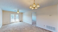 Located at 2406 Tillery Ln in Phenix City, Alabama, this single-story, one-bedroom, one-bathroom home offers a well-organized and functional layout. The living room serves as the heart of the home, featuring soft carpeting, a textured ceiling, a gold chandelier, and a ceiling fan. A set of French doors floods the space with natural light and provides access to an outdoor area, creating an open and airy feel. The living room connects seamlessly to the bedroom, which also features plush carpet, a ceiling fan, a window overlooking the outdoors, and a textured ceiling. The kitchen is efficiently designed with white cabinetry trimmed in warm wood tones, ample counter space, a double-basin sink, a black dishwasher, and a range. Tile flooring adds durability and practicality to this space. The bathroom is well-appointed with a single-sink vanity featuring a light countertop, a tub-shower combination, and tile flooring. A closet with built-in shelving is accessible from the bathroom, providing useful storage. Throughout the home, neutral tones and consistent finishes create a cohesive and inviting atmosphere.