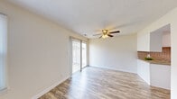 Located at 2402 Flint Dr in Wilmington, NC, this two-story, 3-bedroom, 2-bathroom home offers a practical and comfortable layout spread across two floors. The main level features a bright living room with hardwood-style flooring, a ceiling fan with light fixture, and a sliding glass door that opens to the outdoors, allowing generous natural light to fill the space. The kitchen is well-appointed with white cabinetry, a tile backsplash, laminate countertops, a stainless steel sink, and white appliances including a range, dishwasher, and range hood. A full bathroom on this level features wood-style flooring and a vanity with ample counter space. Upstairs, the three bedrooms are finished with plush carpeting and ceiling fans. The spacious primary bedroom includes direct access to a large walk-in closet. A secondary bedroom features dual closets — one with a hanging rod and the other with built-in shelving — offering excellent storage versatility. The upper-level bathroom includes a shower with a decorative curtain, a white vanity, and wood-style flooring. A hallway and staircase connect both floors seamlessly, making this home a well-organized and functional residence.