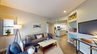 This single-floor residence offers a thoughtfully designed open-concept layout that seamlessly connects the living, dining, and kitchen areas. The living room features warm hardwood-style flooring, recessed lighting, and large sliding glass doors dressed with vertical blinds that flood the space with natural light. Built-in shelving adds a charming architectural touch alongside the seating area.

The kitchen is well-equipped with stainless steel appliances, including a range, microwave, and dishwasher, complemented by crisp white cabinetry, a classic subway tile backsplash, and a granite-topped island with a double stainless steel sink — ideal for both cooking and casual dining.

The primary bedroom is generously sized with plush carpeting, a large sliding-door closet, and a sliding glass door that brings in ample natural light. The second bedroom also features mirrored sliding closet doors and soft carpeted flooring. Both bathrooms are finished with granite countertops, white cabinetry, and wood-look tile flooring. One bathroom includes a shower-tub combination, while the other features a walk-in shower. Throughout, neutral tones and clean lines create a calm, cohesive ambiance suited to modern living.