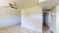 Located at 510 N Horne in Mesa, AZ, this two-bedroom, one-bathroom unit offers a practical and efficient single-floor layout. Consistent light tan tile flooring runs throughout the entire space, providing a cohesive and easy-to-maintain foundation. Painted white brick walls lend a distinctive architectural character to each room.

The kitchen is well-appointed with white cabinetry, a classic subway tile backsplash, and stainless steel appliances including a refrigerator, electric range, and microwave. A rear door in the kitchen provides direct outdoor access and brings in natural light.

Both bedrooms feature ceiling fans, painted brick walls, and natural light from individual windows. Each room includes a sliding-door closet for storage. The primary bedroom offers a comfortable footprint, while the second bedroom is similarly functional in scale.

The bathroom is clean and straightforward, featuring a walk-in shower with built-in shelving, a white vanity with a light stone-look countertop, and tile flooring. A small window above the shower provides ventilation and additional light.

A hallway connects the main living areas and bedrooms, with arched doorway details adding a subtle design touch. The overall ambiance of the unit is bright, clean, and functional, well-suited for everyday living in the Mesa, AZ area.